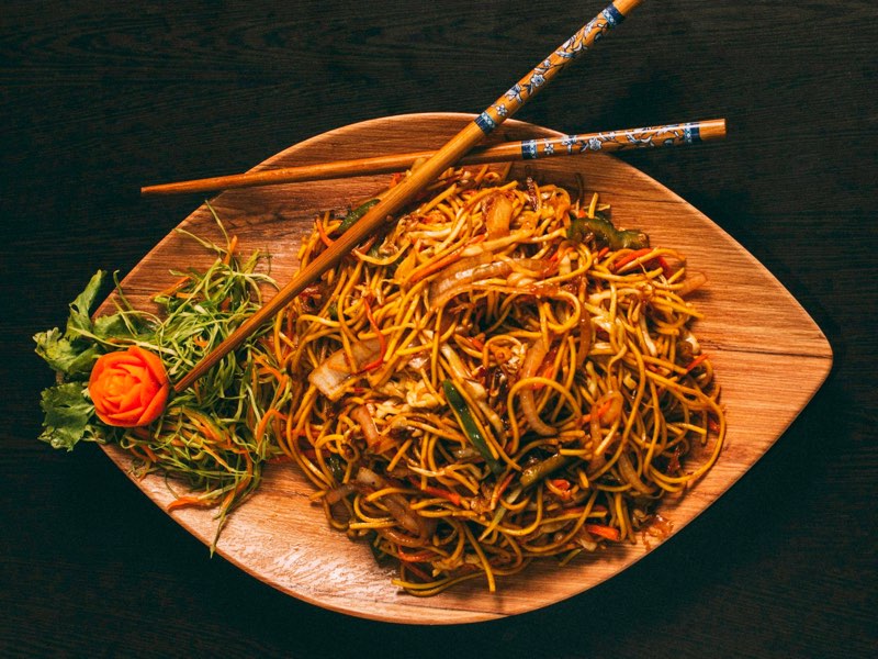 Stir-fried lo mein noodles with vegetables and chopsticks