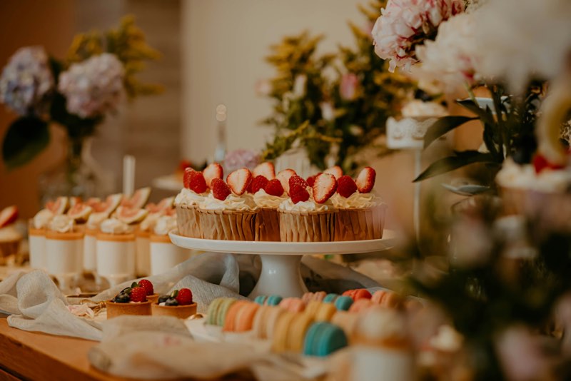 Dessert table with cupcakes, cream cups and pastries